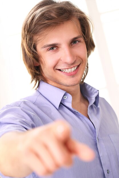 Handsome smiling guy pointing at camera