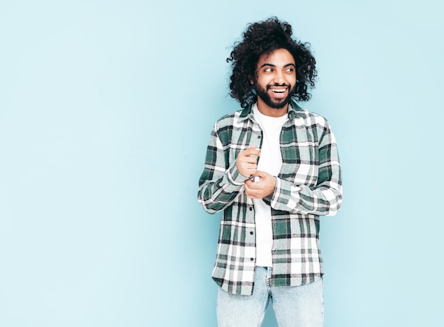 Foto gratuita uomo sorridente bello dei pantaloni a vita bassa che posa nello studio