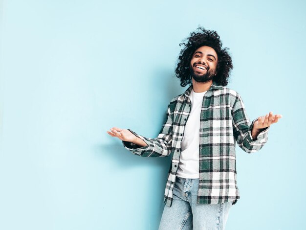 Handsome smiling hipster man posing in studio