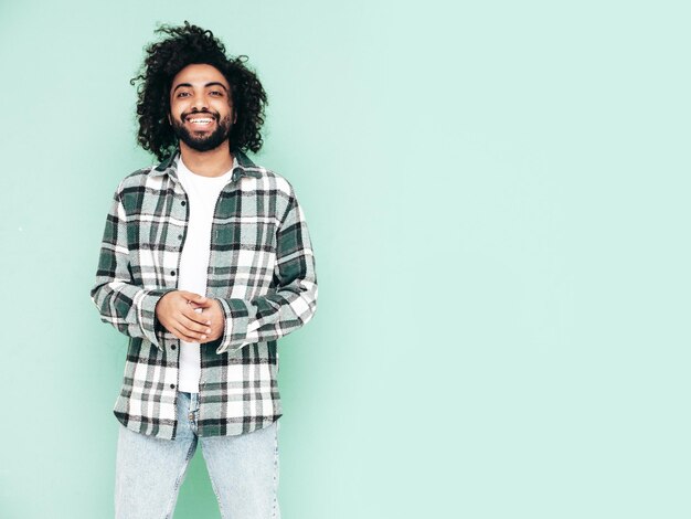 Handsome smiling hipster man posing in studio