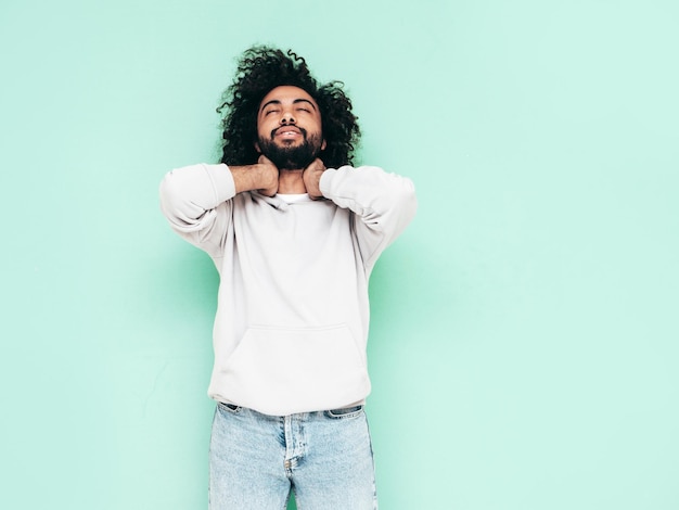 Foto gratuita uomo sorridente bello dei pantaloni a vita bassa che posa nello studio