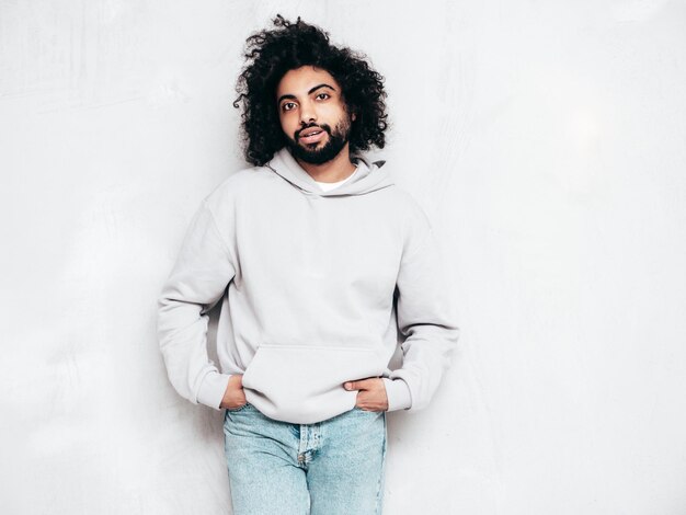 Handsome smiling hipster man posing in studio