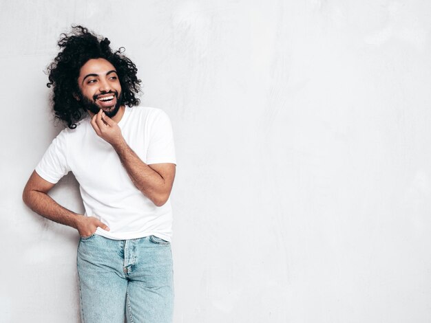 Handsome smiling hipster man posing in studio