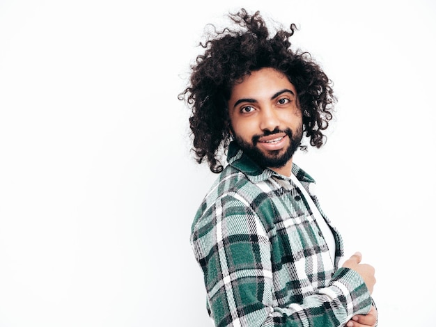 Free photo handsome smiling hipster modelsexy unshaven arabian man dressed in summer shirt and jeans clothes fashion male with long curly hairstyle posing near wall in studio isolated on white