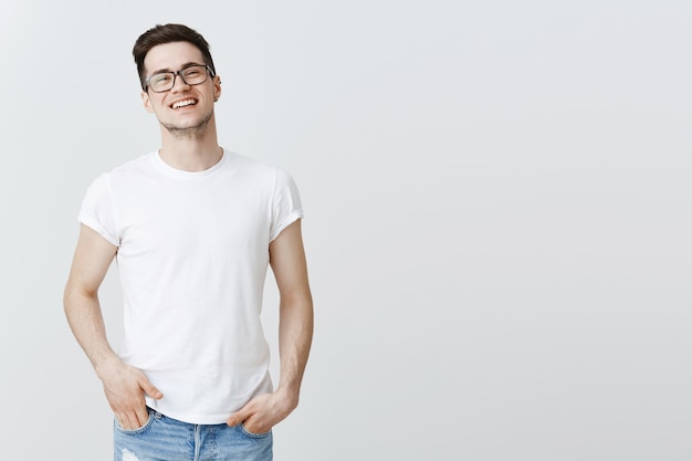 Handsome smiling man in glasses standing