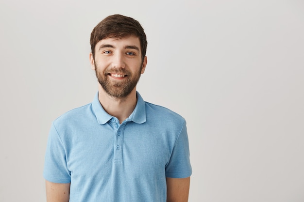 Handsome smiling young bearded man posing