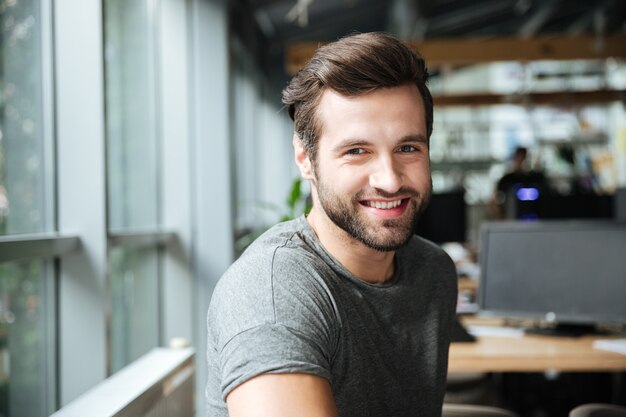 사무실 coworking에 앉아 잘 생긴 웃는 젊은이