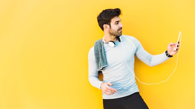 Handsome sportsman using smartphone