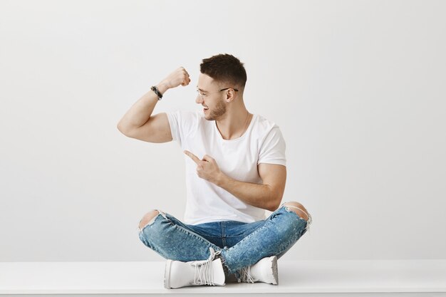 Handsome strong young guy with glasses posing