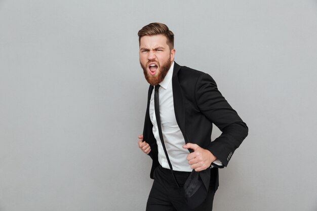 Handsome stylish businessman in suit posing while standing