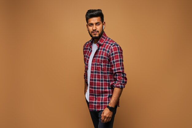 Handsome stylish indian model man in casual close posing on pastel wall