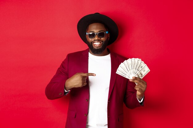 Handsome and stylish male model showing money and smiling