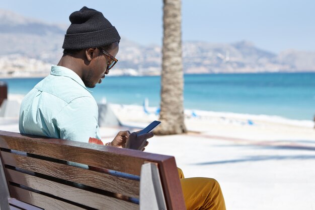 handsome stylish young male using an electronic device on a sunny day