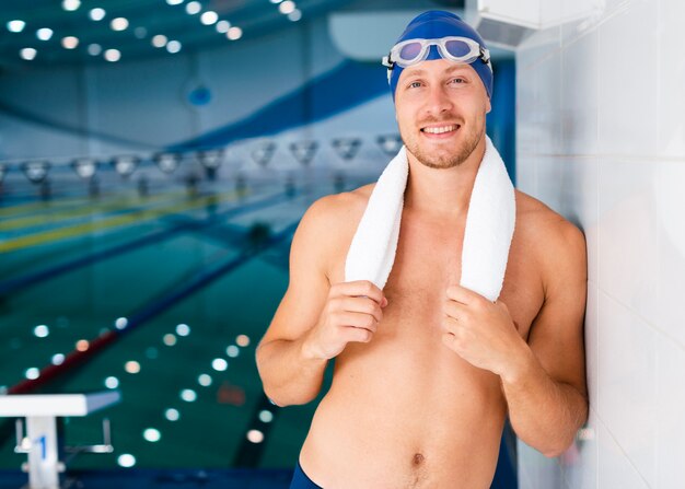 Handsome swimmer holding his towel