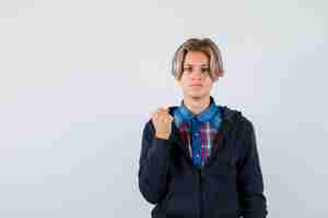 Free photo handsome teen boy in shirt, hoodie showing clenched fist and looking angry , front view.