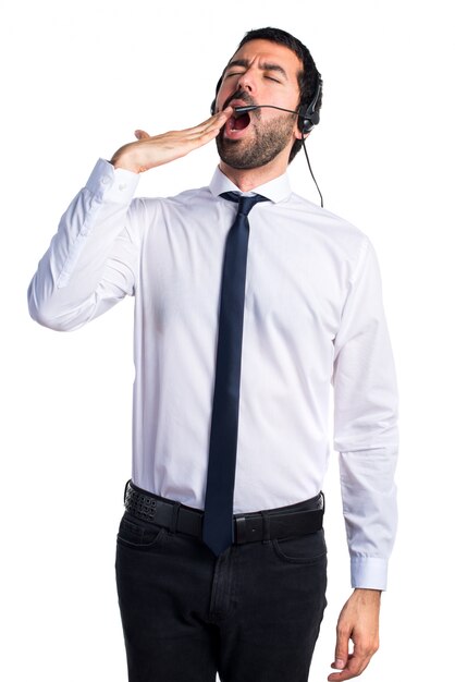 Handsome telemarketer man yawning