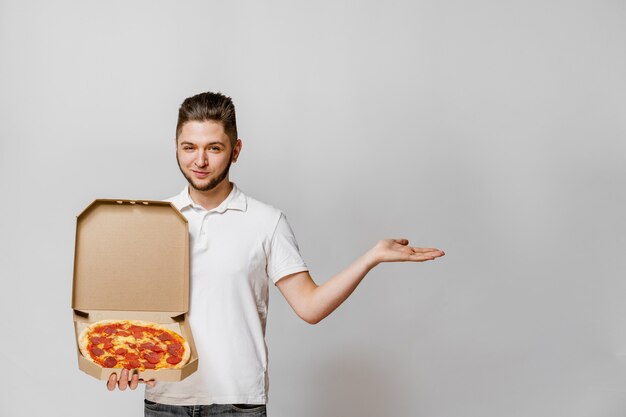 ピザ付き​の​ハンサムな​若者​の​宅配便​は​、​テキスト​広告​の​ため​の​空き​スペース​を​指します