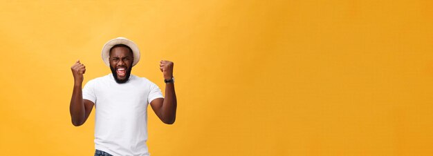 Бесплатное фото Красивый молодой афроамериканский сотрудник чувствует себя взволнованным, активно жестикулируя, сжимая кулаки