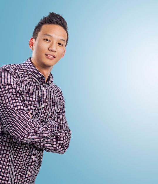 Free photo handsome young asian man over a blue background