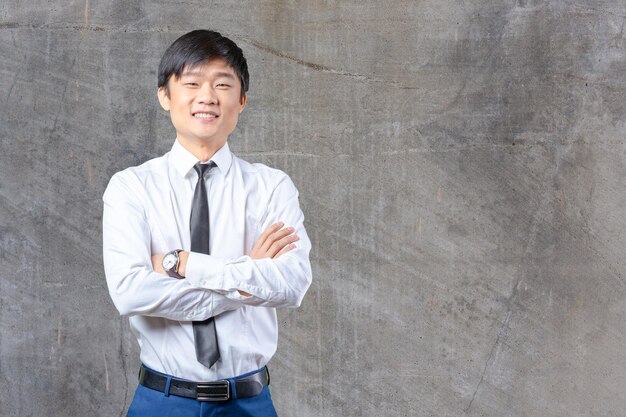 Handsome young asian man standing wearing a suit