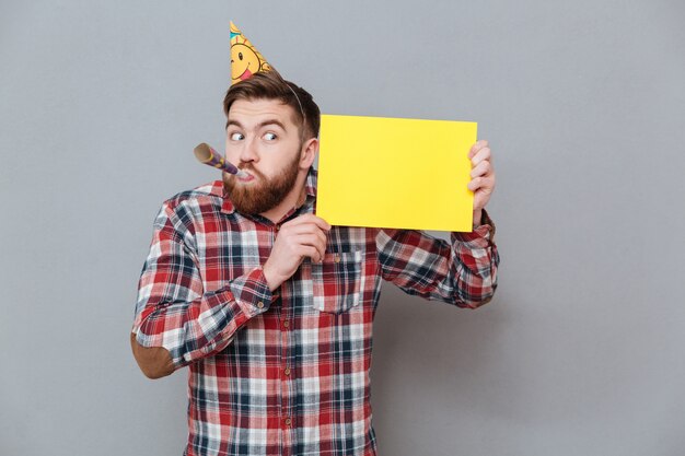 Handsome young bearded birthday man holding blank board