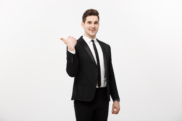 Handsome young business man happy smile point finger to empty copy space, businessman showing pointing side, concept of advertisement product, isolated over white background.