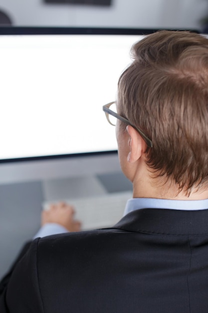 Free photo handsome young business man working with computer in office.