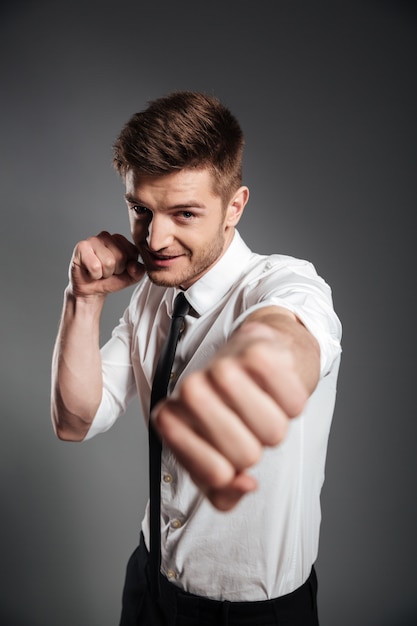 Handsome young businessman in formalwear boxing
