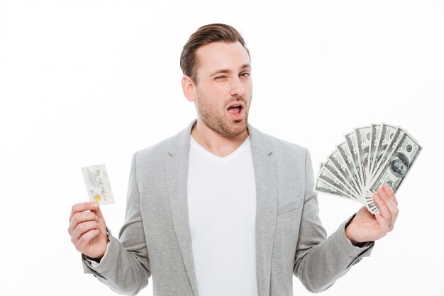 Handsome young businessman holding credit card and money