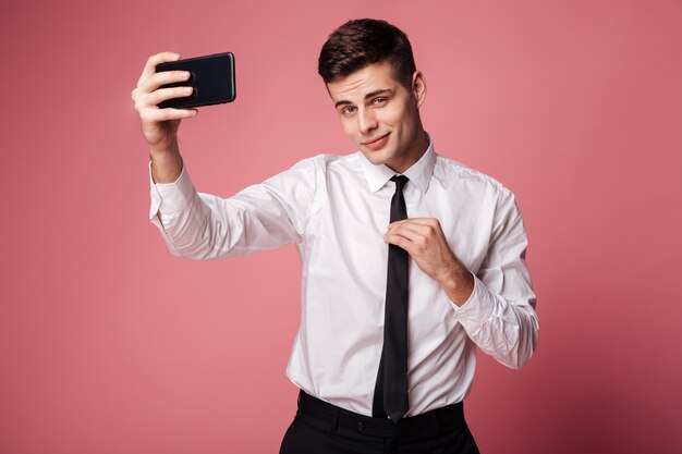 Handsome young businessman make selfie by mobile phone.