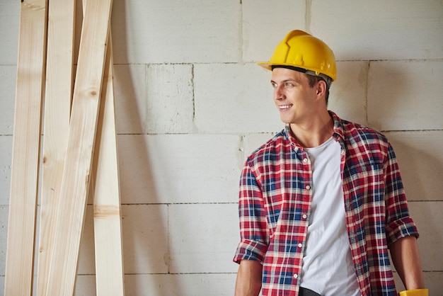 Free photo handsome young carpenter stands in workshop