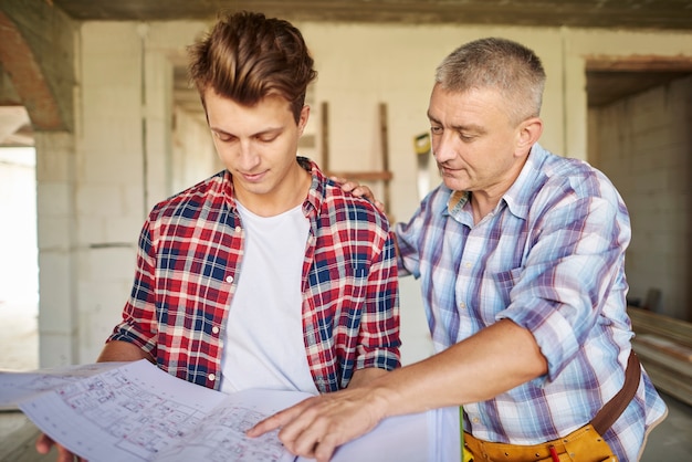 Handsome young carpenter working with an experienced man