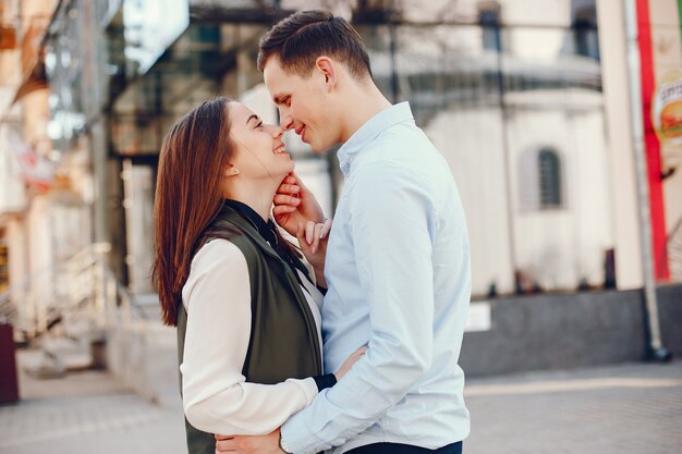 handsome young guy in a blue shirt walks in a sunny summer city along with her cute girl 