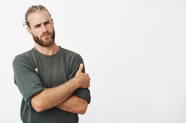 Handsome young hipster man posing with crossed arms