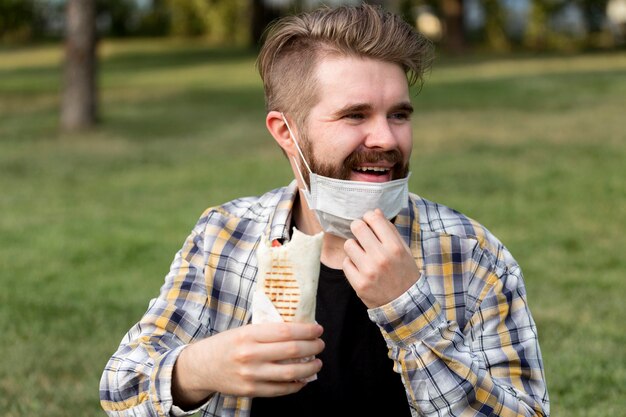 Handsome young male holding kebab