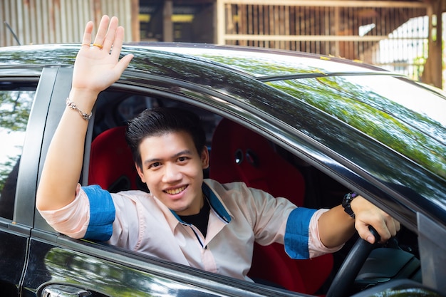 Handsome young man in black car