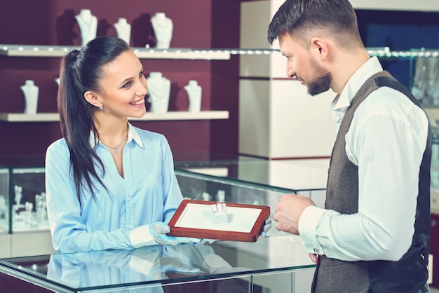 Handsome young man buying jewelry at the local jewelry store