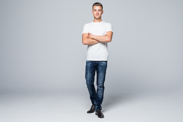Красивый молодой человек в повседневной одежде, белая футболка и синие джинсы на белом