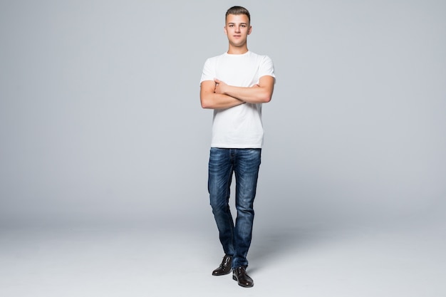 Handsome young man in a casual style clothing white t-shirt and blue jeans on white