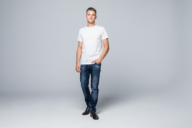 Free photo handsome young man in a casual style clothing white t-shirt and blue jeans on white