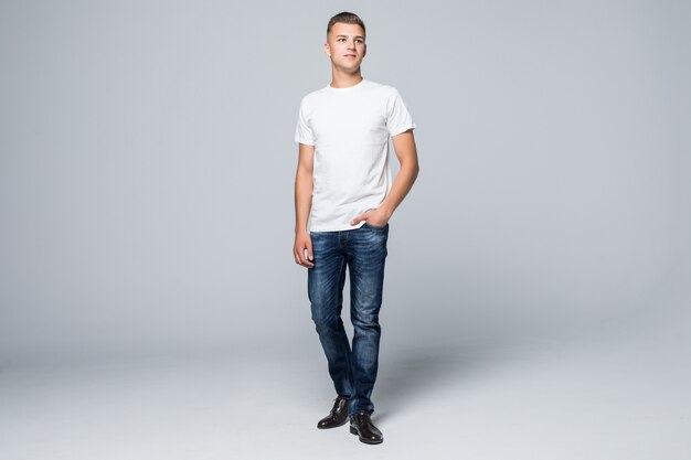 Handsome young man in a casual style clothing white t-shirt and blue jeans on white