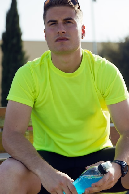 Free photo handsome young man drinking after running.