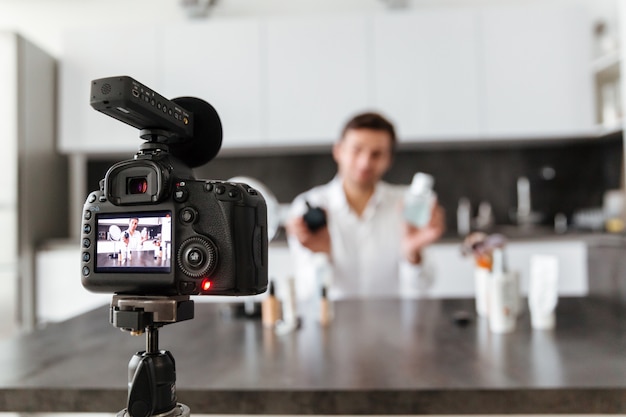 Free photo handsome young man filming his video blog episode