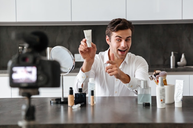 Handsome young man filming his video blog episode