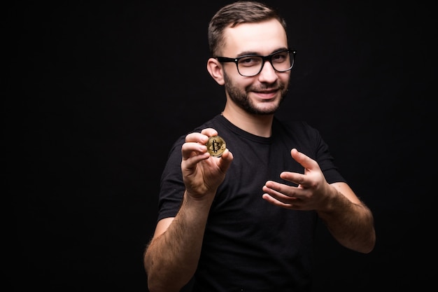 Free photo handsome young man in glasses wear in black shirt present bitcoin isolated on black