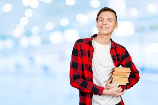 Handsome young man holding books