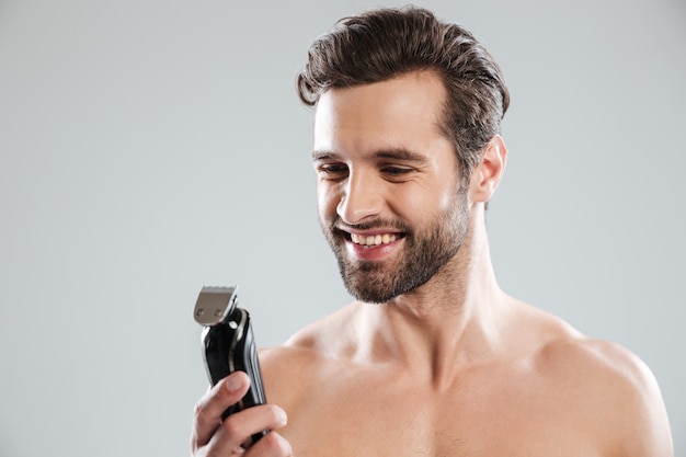 Handsome young man holding electric razor