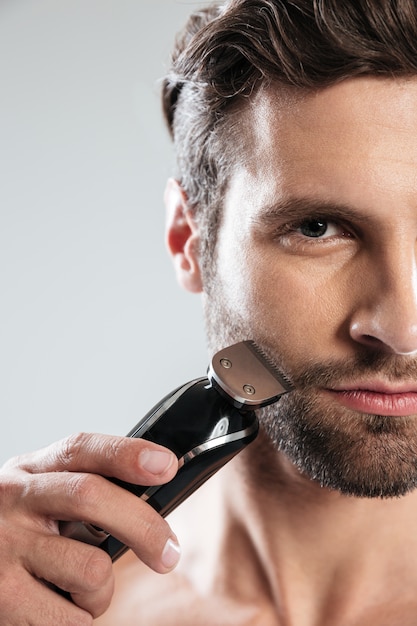 handsome young man holding electric razor