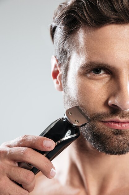 Handsome young man holding electric razor