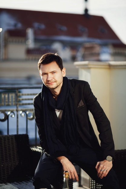 Handsome young man sits on the chair outdoors